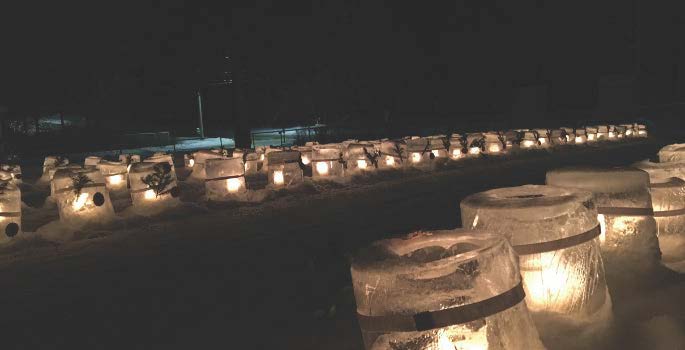 ice candles glowing at night in a snowy field